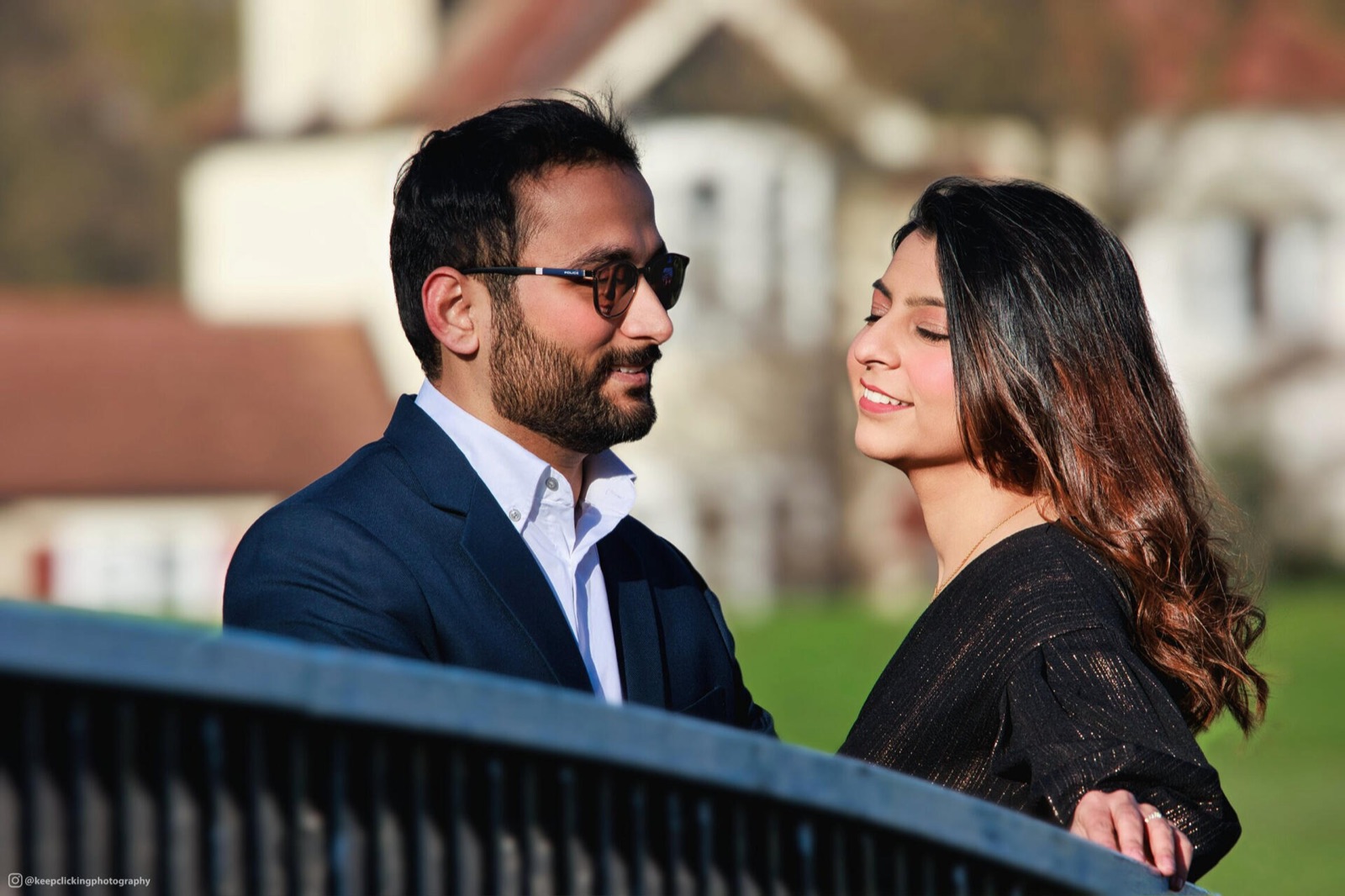 Couple smiling at each other on a bridge
